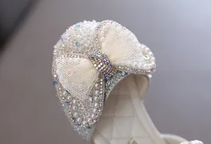 Nahaufnahme der exquisiten Strass- und Perlen-Schleife auf Mädchen-Prinzessin-Tanzschuhen