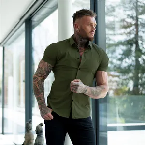 Muscle fit olive green short sleeve button down shirt for men in modern indoor setting