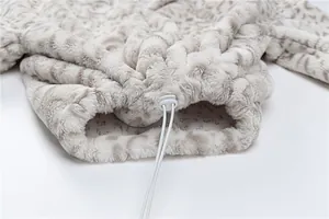 Close-up of adjustable drawstring toggle on leopard print plush fleece sweatshirt hem.