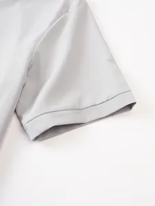 Close-up detail of a grey short sleeve shirt hem showing precise stitching and fabric texture