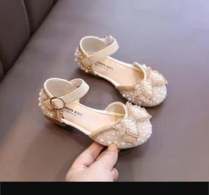 Vue détaillée des sandales de princesse beiges pour filles ornées de perles et d'un nœud chic.