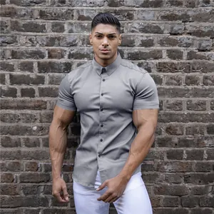 Grey short sleeve muscle fit shirt with stretch fabric shown in detail against brick wall