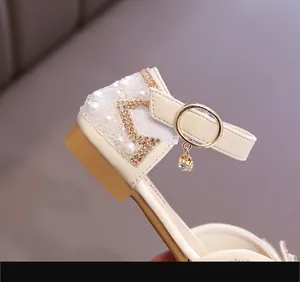 Gros plan d'une sandale de princesse pour fille avec perles, strass et étoile.