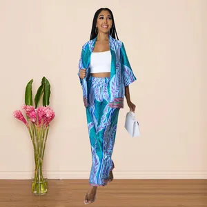 Model wearing blue printed faux silk kimono set with wide-leg pants in indoor setting