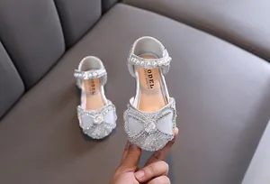 Detail view of silver girl's princess shoes with sparkling rhinestones and a bow