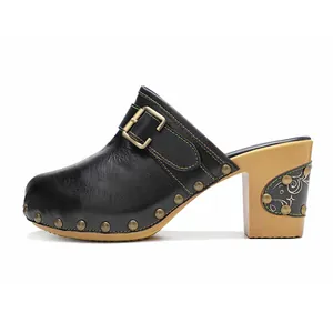 Vue latérale détaillée de sabots vintage en cuir noir avec surpiqûres colorées et boucle