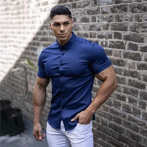 Detail shot of navy blue muscle fit short-sleeve shirt worn by a fit model outdoors