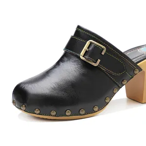 Vue détaillée de sabots en cuir noir rétro faits main avec boucle décorative et rivets en métal
