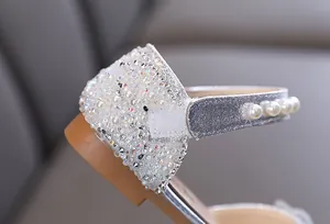 Detailed macro view of sparkly silver girls princess shoes with rhinestones and pearls