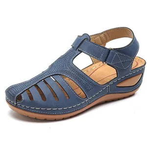 Primer plano de sandalias azules con cuña y punta cerrada con diseño calado y velcro