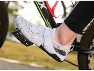 Detail of white outdoor cycling shoe with adjustable velcro straps on a bike pedal