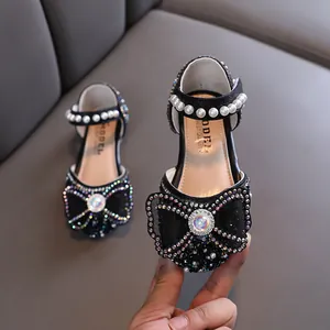 Elegant girls' black princess shoes with sparkly crystal bows and pearl straps for dress wear.