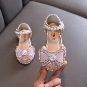 Elegant pink girls' princess shoes featuring a rhinestone bow and decorative pearls
