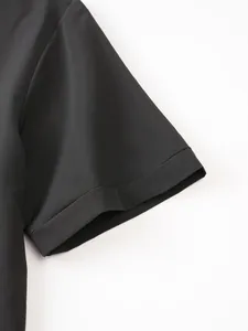 Macro view of the sleeve cuff on a black stretch men's polo shirt with fine stitching details