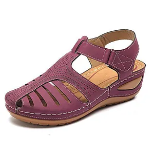 Detalle de primer plano de sandalias de cuña moradas con calados y costuras blancas