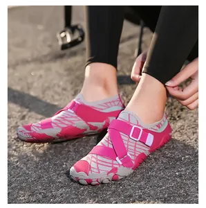 Close-up detail of pink and grey patterned outdoor water shoes worn on pavement surface