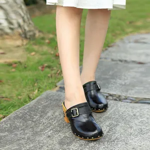 Vue détaillée de sabots en cuir noir faits main avec boucle métallique et talon bloc vintage