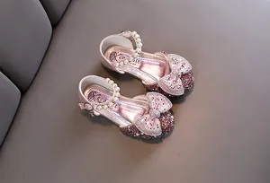 Detailed view of pink glittery girls' princess shoes with pearl strap and bow decorations