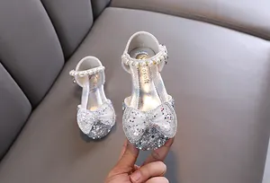 Close-up of girl's silver princess shoe with sparkling bow and rhinestone toe detail