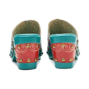 Vue détaillée de sabots vintage en cuir à fleurs avec talons épais et ornements cloutés
