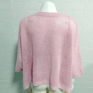 Close-up detail of a pink mesh hollow-out knit beach bikini cover-up on a mannequin