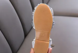 Macro detail of anti-slip rubber sole for toddler girl's sparkly silver princess flat shoes