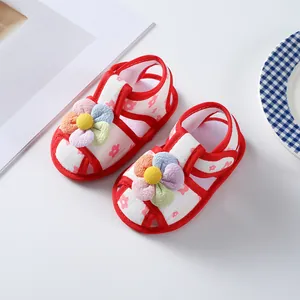 Close-up detail of infant girl summer walking shoes featuring colorful 3D plush flowers