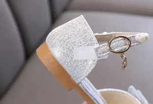Close-up detail of silver glitter girl's princess shoe with pearl strap and velcro fastener
