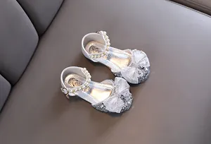 Detailansicht der funkelnden silbernen Prinzessinnenschuhe mit Schleife und Perlenriemen