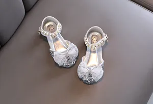 Detailansicht funkelnder silberner Prinzessinnenschuhe für Mädchen mit weißer Spitzenschleife