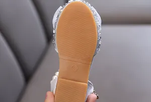 Nahaufnahme der rutschfesten Gummisohle von silbernen Prinzessinnenschuhen für Mädchen