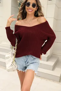 Detailed view of women's burgundy v-neck long sleeve chunky knit sweater on model