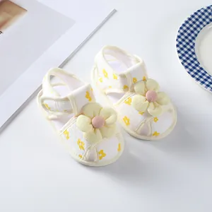 Detailed view of white infant girl summer sandals with 3D yellow floral design