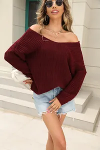 Full-body view of a model wearing a burgundy V-neck chunky knit sweater with denim shorts