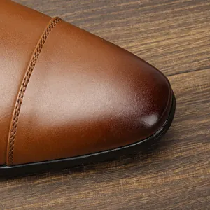 Dettaglio macro della punta in pelle patinata di classiche scarpe Oxford marroni