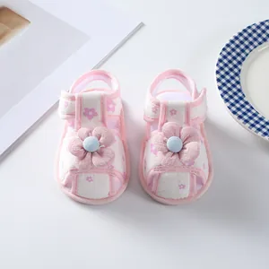 Close-up of pink fabric infant sandals featuring delicate cloth flower decorations