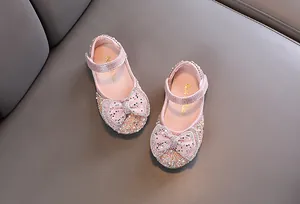 Dettaglio delle scarpe da principessa rosa glitterate per bambina con fiocco e strass