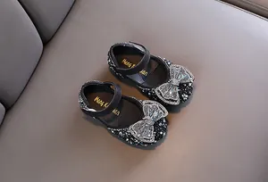 Dettaglio scarpe da principessa nere per bambina con fiocco di strass e perle