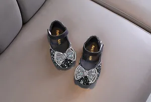Dettaglio delle scarpe da principessa nere per bambina con fiocco in strass scintillanti