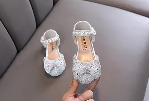 Detailansicht silberne Mädchen Prinzessinenschuhe mit Perlenriemen und Schleife