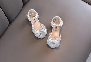 Draufsicht auf silberne Mädchen-Prinzessin-Schuhe mit Perlen und Schleife