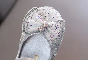 Primo piano di scarpa da principessa per bambina con grande fiocco di strass