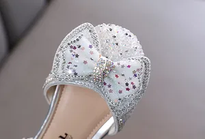 Detailansicht eines Mädchen-Prinzessin-Schuhs mit Pailletten-Schleife und glitzernden Steinen