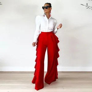 Modelo con pantalones rojos de talle alto con volantes y camisa blanca de mangas abullonadas