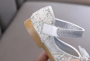 Dettaglio scarpe da principessa per bambina con strass luccicanti e cinturino velcro.