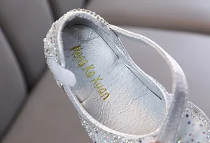 Dettaglio di scarpa da principessa argento per bambina con sottopiede firmato