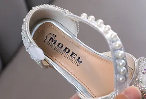 Makrodetail der silbernen Mädchenprinzessin-Schuhe mit Perlen und funkelnden Strasssteinen