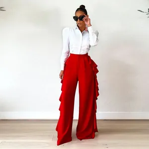 Elegante pantalón rojo de cintura alta y pierna ancha con volantes laterales en capas.