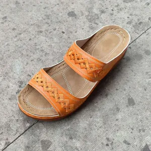 Detailed close-up view of orange wedge sandals featuring intricate diamond embroidered straps