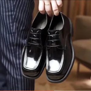 Nahaufnahme von schwarzen Herren-Lederschuhen mit eckiger Zehenpartie und Glanz.